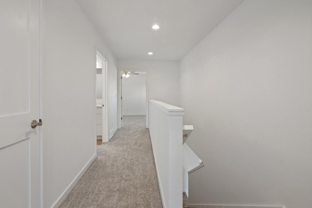 hallway featuring an upstairs landing, recessed lighting, light carpet, and baseboards