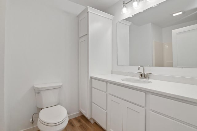 bathroom with wood-type flooring, vanity, and toilet