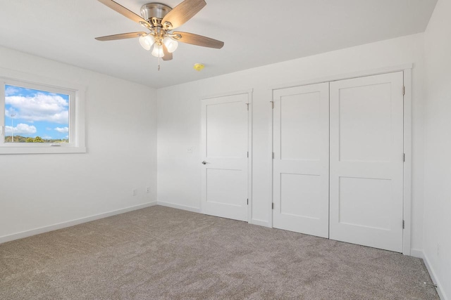 unfurnished bedroom featuring a closet, a ceiling fan, baseboards, and carpet floors