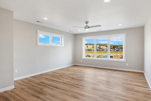 spare room featuring light wood-style flooring, recessed lighting, a ceiling fan, and baseboards