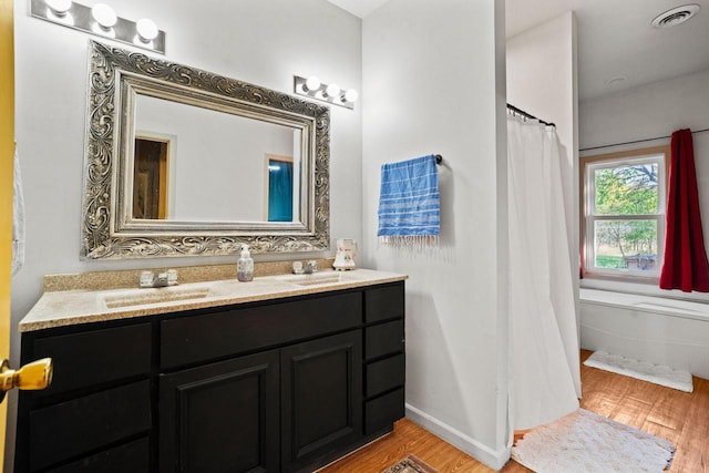 bathroom with vanity, shower / bath combo with shower curtain, and hardwood / wood-style flooring