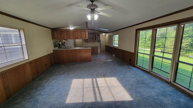 unfurnished living room with crown molding, ceiling fan, and light colored carpet