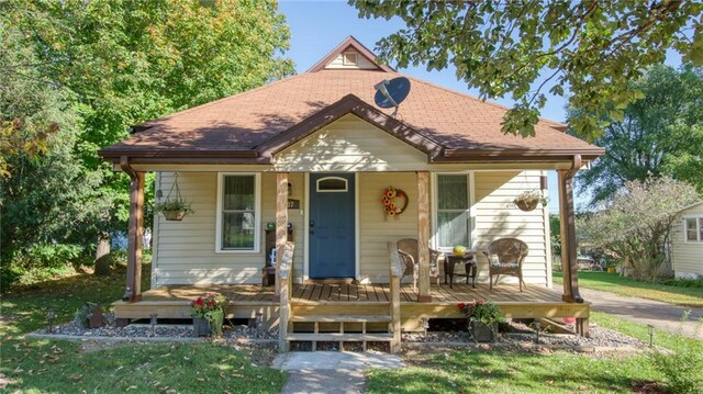 bungalow-style house with a front yard and covered porch