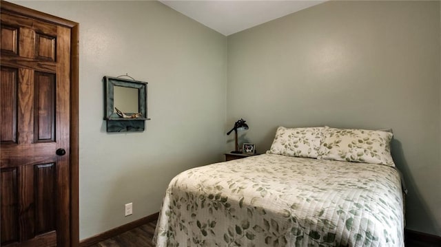 bedroom featuring vaulted ceiling and dark wood-type flooring