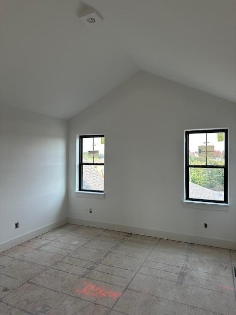 spare room featuring a healthy amount of sunlight and vaulted ceiling