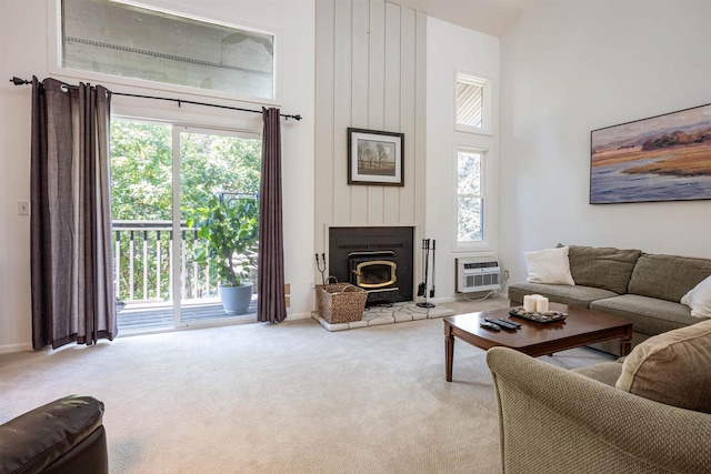 living room with a healthy amount of sunlight, a towering ceiling, and light colored carpet