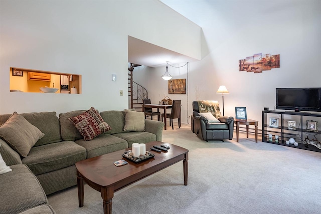 carpeted living room featuring a towering ceiling and a wall mounted air conditioner