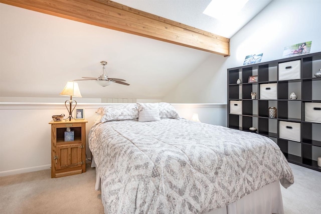 carpeted bedroom with ceiling fan and vaulted ceiling with skylight