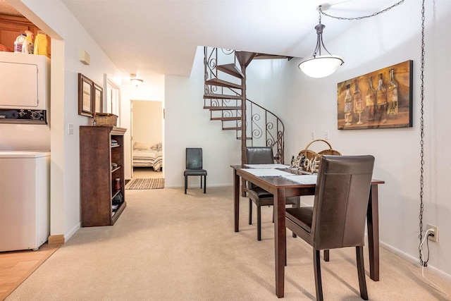 carpeted dining room featuring stacked washing maching and dryer