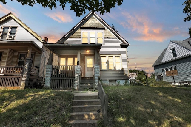 view of front of property with covered porch and a yard