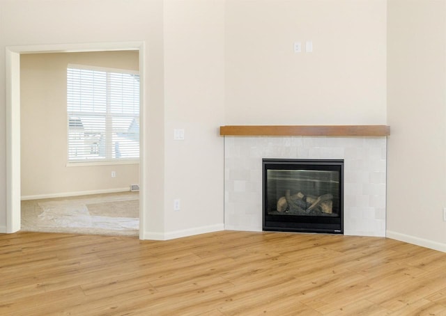 room details with a tile fireplace and wood-type flooring