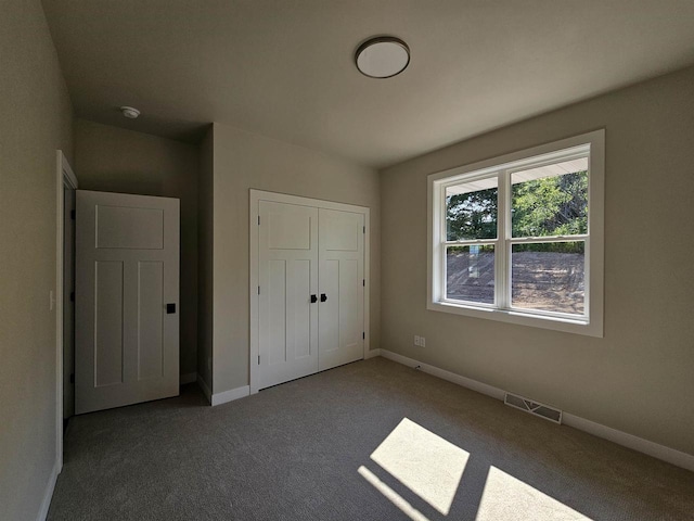 unfurnished bedroom featuring carpet and a closet