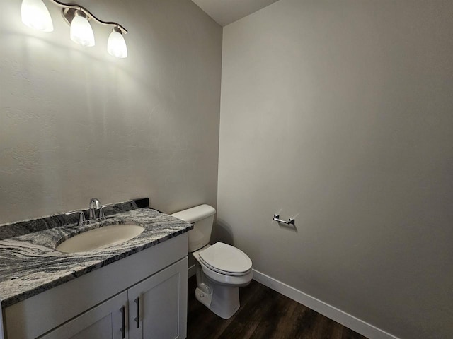 bathroom featuring vanity, toilet, and hardwood / wood-style flooring