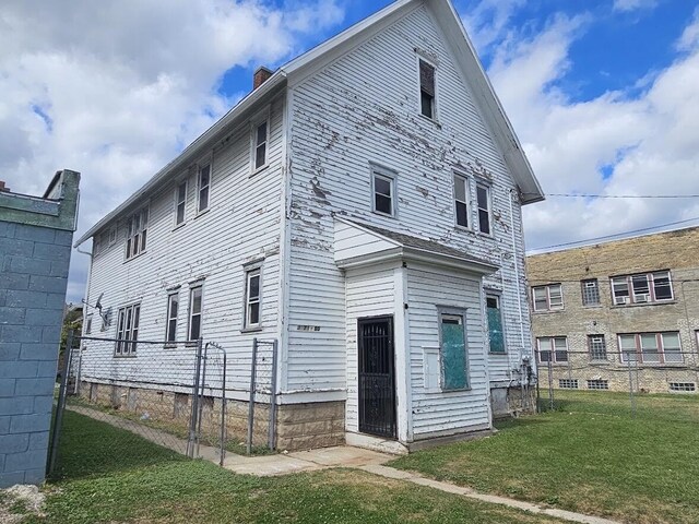 rear view of house featuring a yard