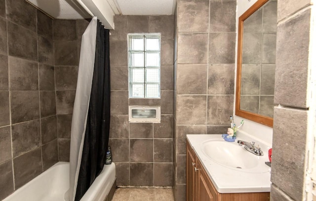 bathroom featuring shower / bath combo, vanity, and tile walls