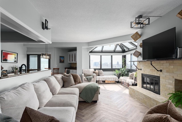 living room featuring parquet flooring, a fireplace, a chandelier, and a wealth of natural light