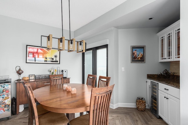 dining space featuring a notable chandelier, beverage cooler, and parquet floors