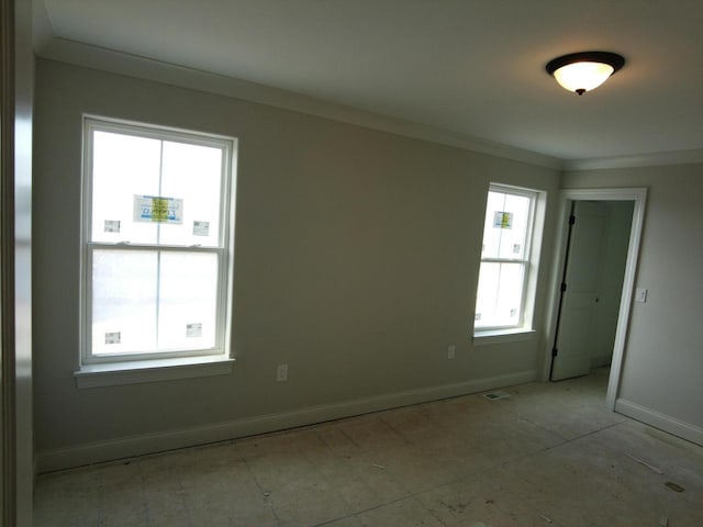 unfurnished room featuring ornamental molding, visible vents, and baseboards