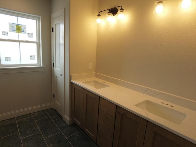 full bathroom with tile patterned flooring, a sink, and baseboards