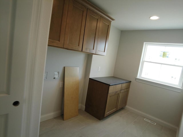 laundry room featuring light tile patterned floors, recessed lighting, visible vents, and baseboards