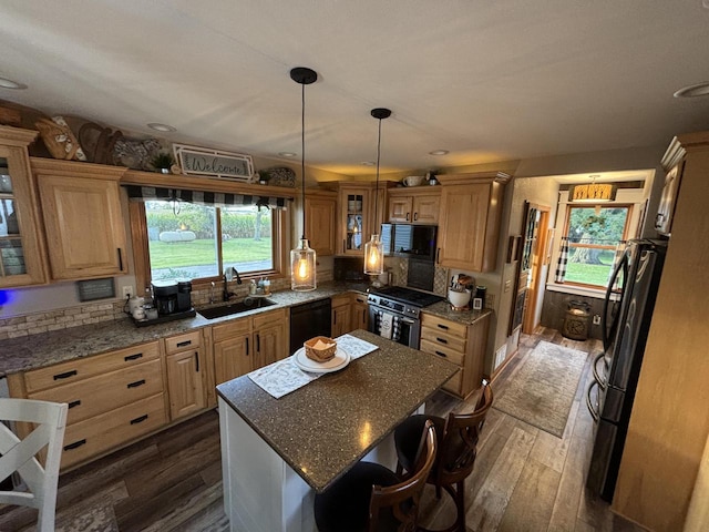 kitchen featuring backsplash, dark hardwood / wood-style floors, black appliances, sink, and a center island