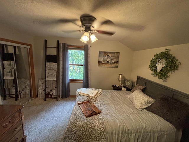 carpeted bedroom with a closet, ceiling fan, a textured ceiling, and vaulted ceiling