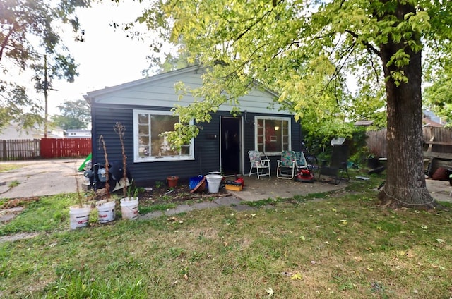 back of property with a patio and a lawn