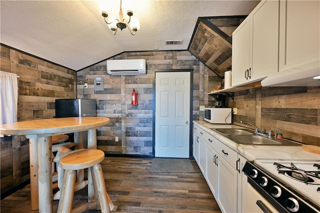 kitchen with white cabinets, wooden walls, vaulted ceiling, and white appliances