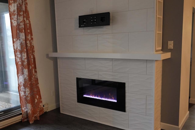 room details featuring hardwood / wood-style floors and a tiled fireplace