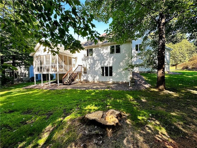 back of property with a sunroom, a lawn, and a patio