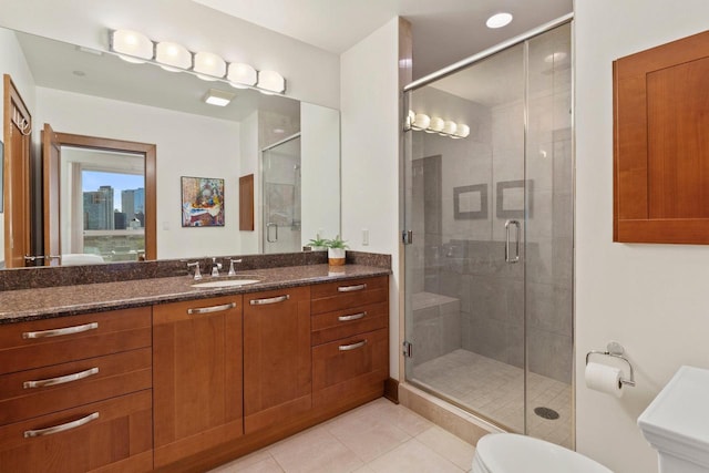 bathroom with tile patterned flooring, vanity, walk in shower, and toilet