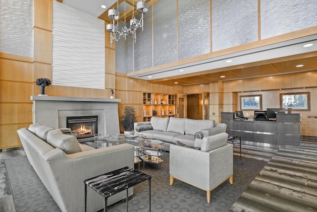 living room with wooden walls, built in features, a towering ceiling, and dark hardwood / wood-style floors