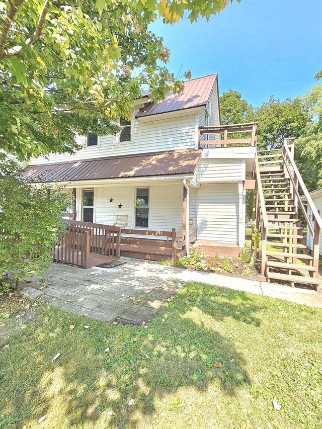 back of house with stairway and a yard