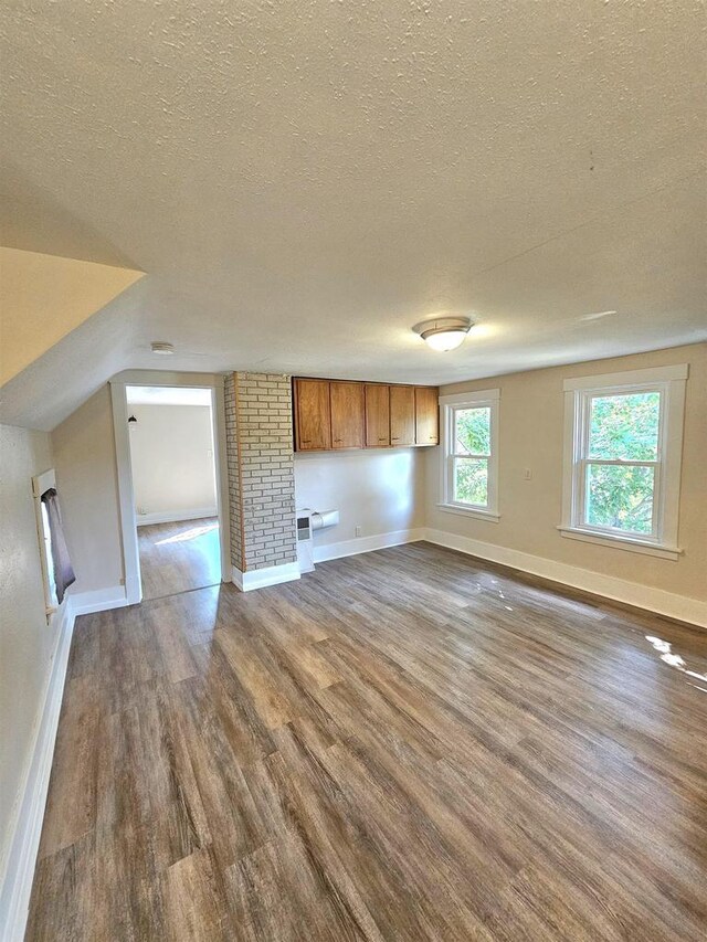 interior space with dark wood-type flooring, baseboards, and a textured ceiling