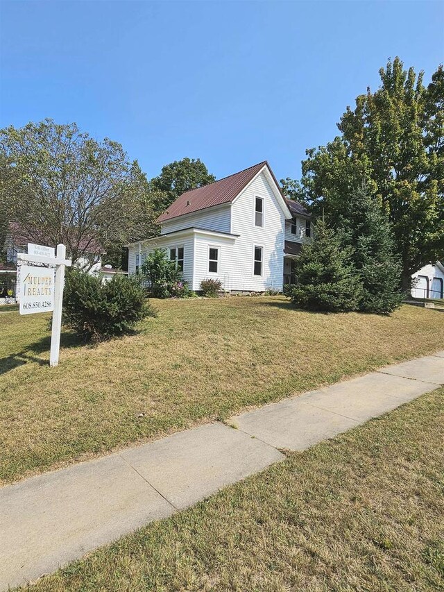 view of front of property with a front yard and metal roof