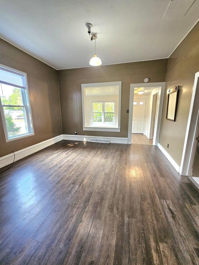 unfurnished living room with baseboards and dark wood finished floors