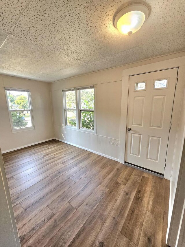 foyer with a textured ceiling and wood finished floors