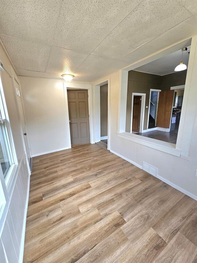 spare room with wood finished floors, baseboards, and visible vents