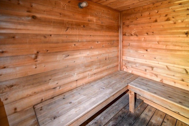 view of sauna / steam room with wood ceiling, wood-type flooring, and wood walls