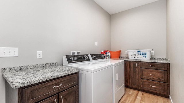 laundry room featuring cabinets, light wood-type flooring, and washing machine and dryer