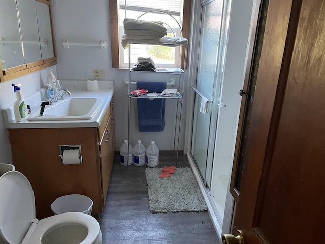 bathroom with a shower with door, toilet, vanity, and hardwood / wood-style flooring