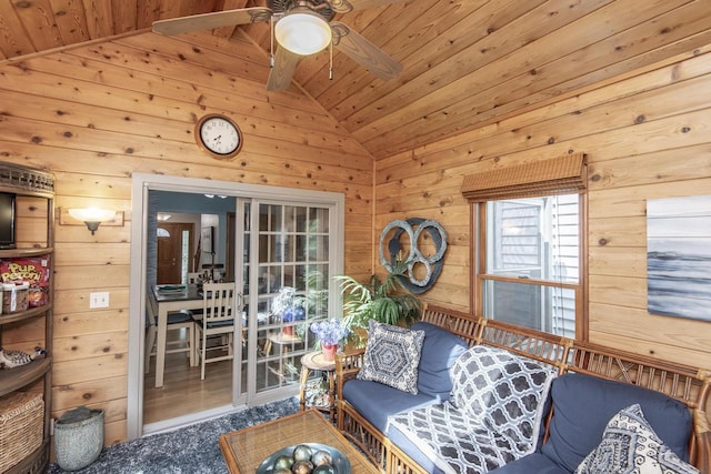 carpeted living room with wooden walls, lofted ceiling with beams, and wood ceiling