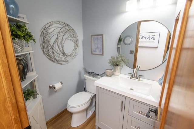 bathroom with toilet, hardwood / wood-style flooring, and vanity