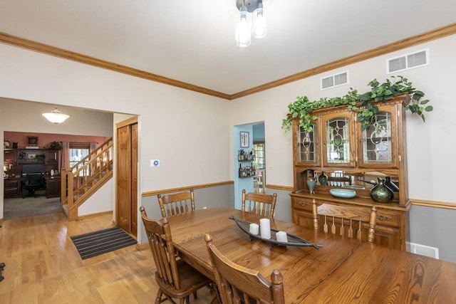 dining area with ornamental molding and light wood-type flooring