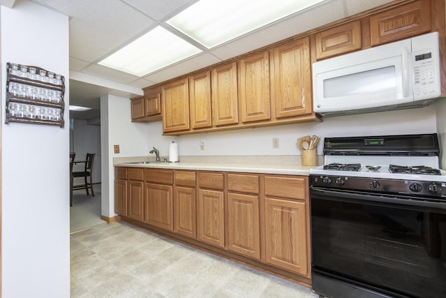 kitchen featuring sink, range with gas stovetop, and a drop ceiling