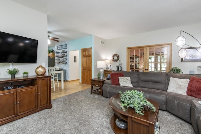 carpeted living room featuring french doors and ceiling fan