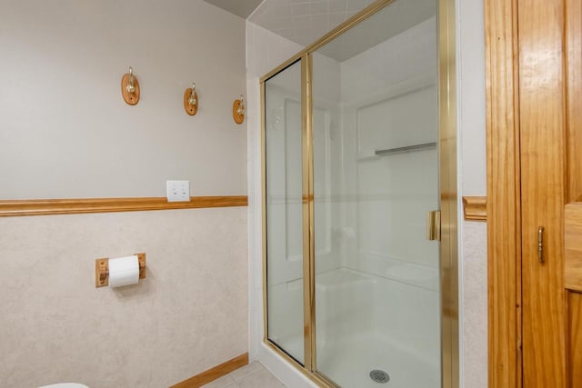 bathroom with tile patterned flooring and a shower with shower door