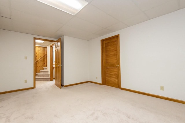 basement with carpet floors and a paneled ceiling