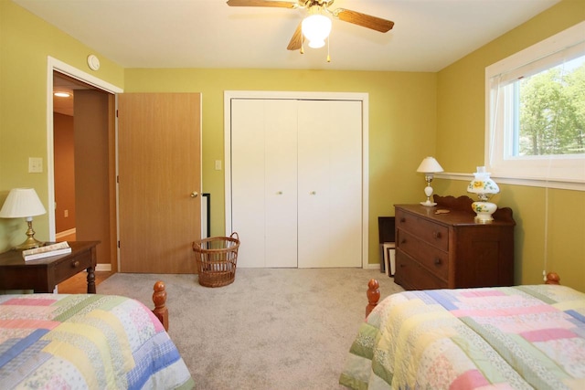 carpeted bedroom featuring ceiling fan and a closet