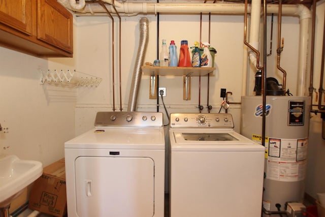 laundry room featuring separate washer and dryer, gas water heater, sink, and cabinets